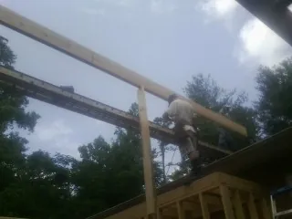 Carpenter setting a ridge beam over a new addition frame — Ice Dam Removal by Roofing Brothers in Claiborne